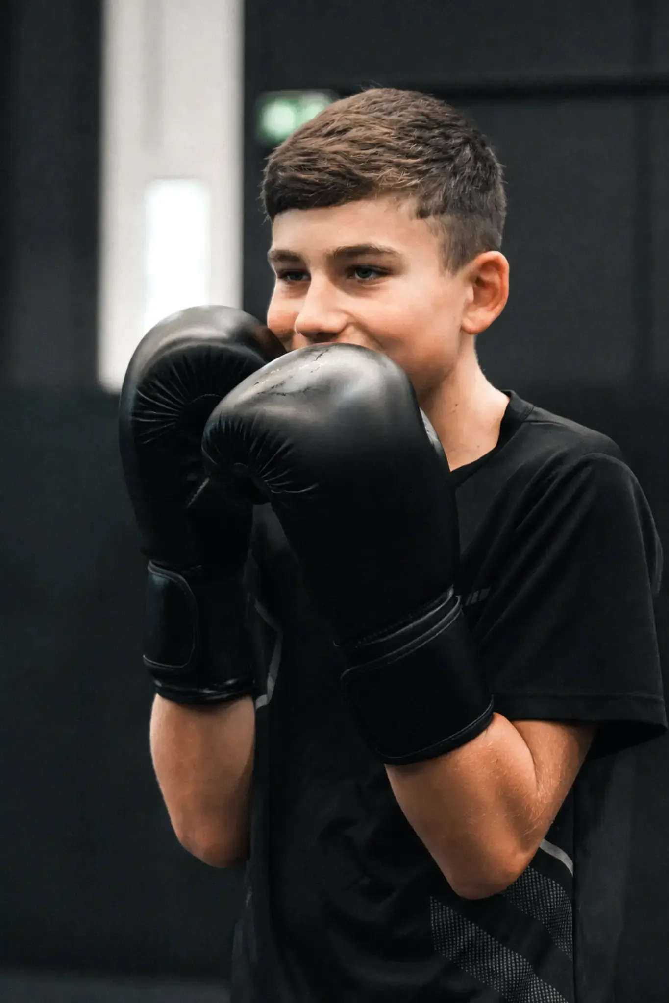 Jeune pratiquant de MMA en garde avec ses gants de boxe